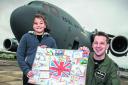 Soffie Rigby and Wing Commander Stuart Lindsell with the giant postcard in front of the C-17 which carried the cards to Afghanistan