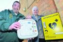 Dick Tracey, of South Central Ambulance Service, left, and Michael Green, vice-chairman of Combe Parish Council with the defibrillator installed at the village's Reading Room