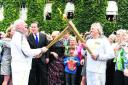 Cancer campaigner Clive Stone, left, transfers the flame to Roland Read, of Oxford