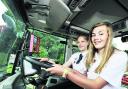 Emma Cook, 11, and Verity Carpenter, 15, try a tractor cab for size