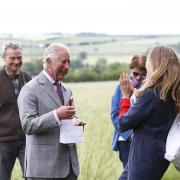 Beekeeper Tanya Hawkes presents Prince Charles with anti-wrinkle cream at FarmED watched by owners Ian and Celene Wilkinson and her daughter Esme. All pictures Ed Nix