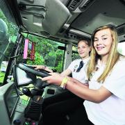 Emma Cook, 11, and Verity Carpenter, 15, try a tractor cab for size