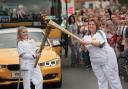 Two of the torch runners pass the flame in Bicester today